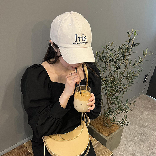 muguetの「iris logo cap」をかぶる女性