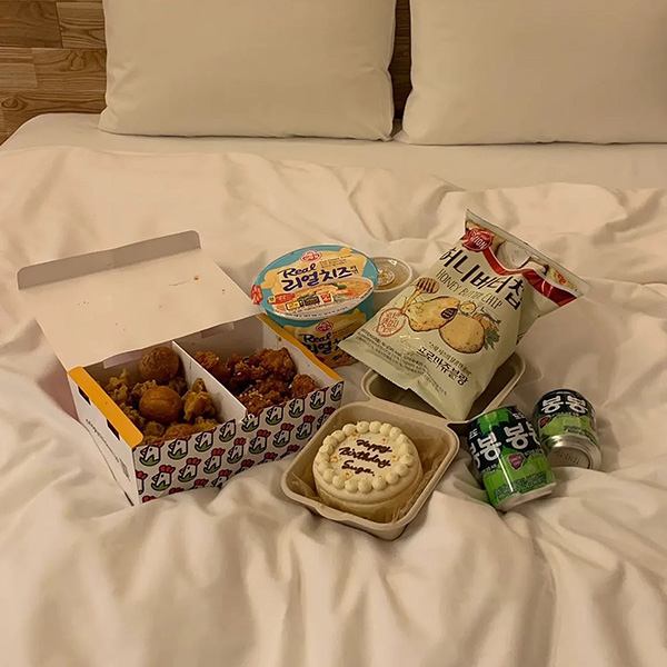 韓国チキンとハニーバターチップなどをベッドに並べて渡韓ごっこ