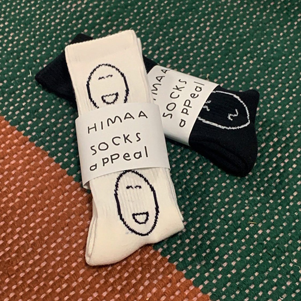 平山昌尚さんが描くHIMAA × socks appealのコラボ靴下のホワイト、ブラック。