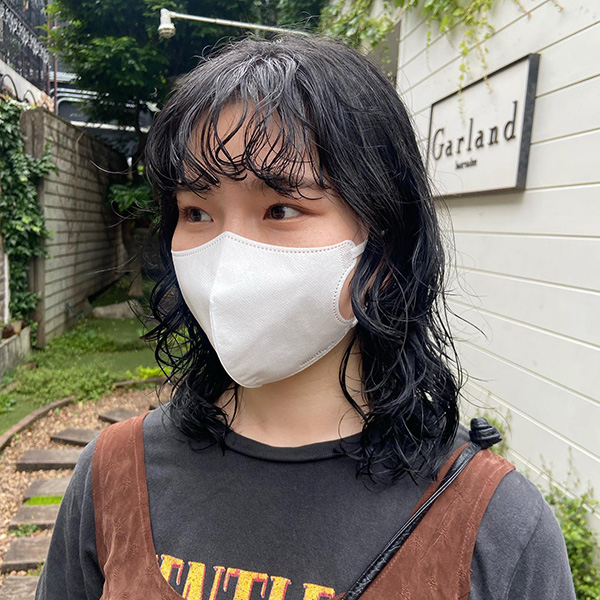 ラフ感がおしゃれな、黒髪パーマヘアの女性