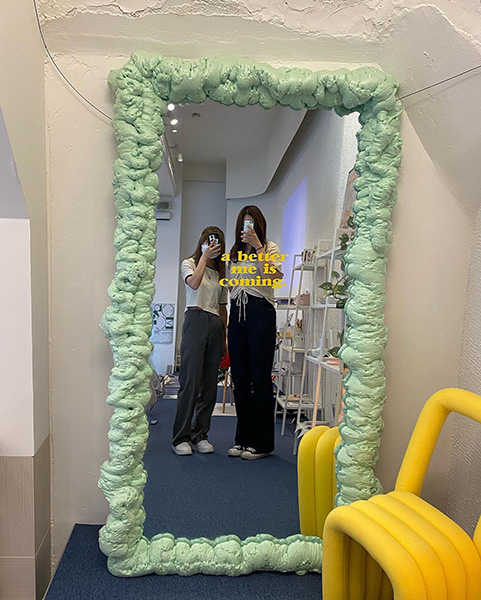 「雑貨とドーナツ」の写真スポットにある鏡で写真を撮る女性2人