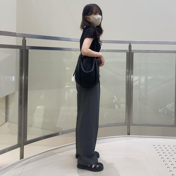 ユニクロで展開されている、タックワイドパンツのグレーを穿いたカジュアルコーデの女性