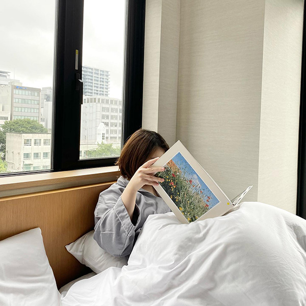 ライトブックスホテル名古屋の静かな客室で本を読む女性