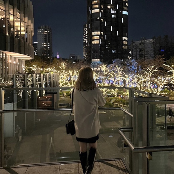 「東京ミッドタウン」のイルミネーションを見る女性