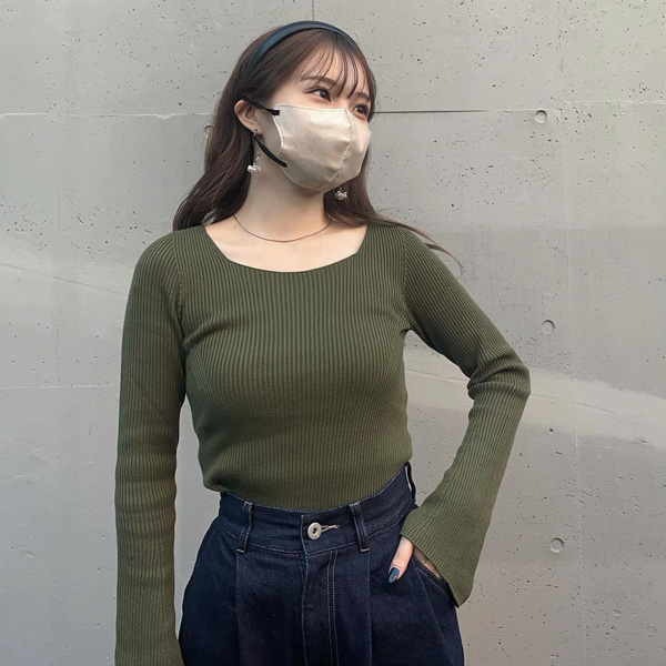 Uniqlo and Mame Kurogouchiで展開されている、3Dリブスクエアネックセーターのオリーブを着た女性