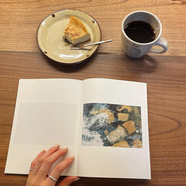 本の読める店「fuzkue」店内で、本を読みながらコーヒーとケーキを楽しむ様子