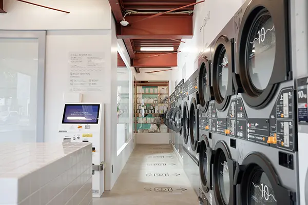 北海道・札幌にリニューアルオープンした「とみおかクリーニング w/ Cafe & Laundry 札幌本店」の店内に並ぶ洗濯機と乾燥機