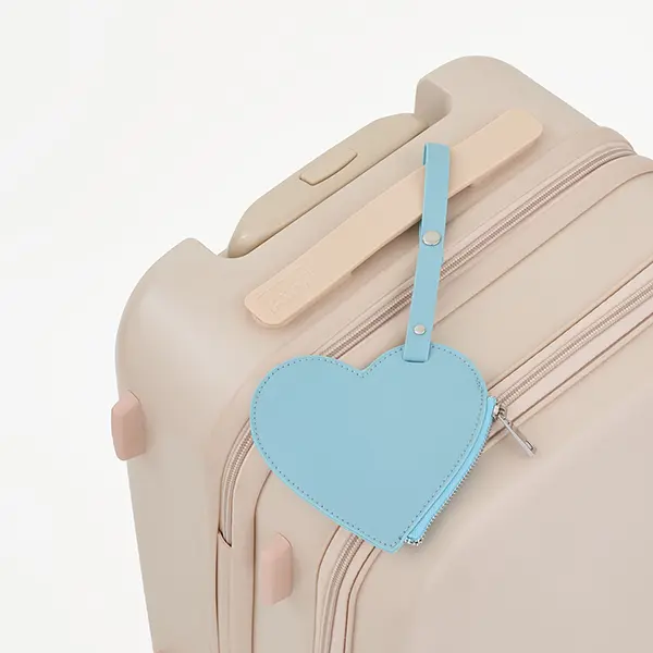 トラベルブランド「Aww」が展開する『アップルレザーシリーズ』の「Apple Vegan Leather Coin Case Set」をスーツケースに取り付けた図