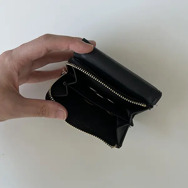 『otona MUSE 2023年12月号』の表紙と付録の「Deuxieme Classe シンプル&ハイクオリティ 究極のミニ財布」の小銭入れの中に小銭を入れ、上から撮影している画像
