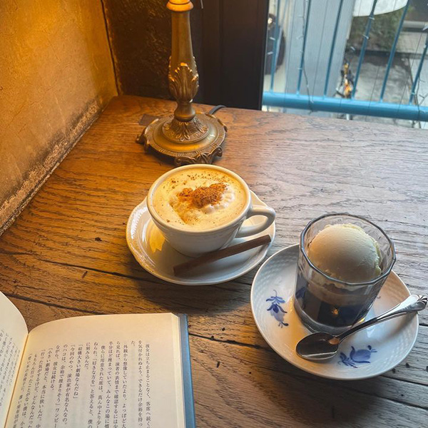 東京・表参道にあるカフェ「Cafe Les Jeux Grenier（カフェ レジュグルニエ）」でアフォガードとカプチーノをお供に本を読んでいる様子