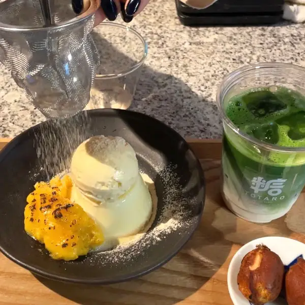 京都カフェ「糖太朗（とうたろう）」の「生プリン 芋」に砂糖をかけている様子