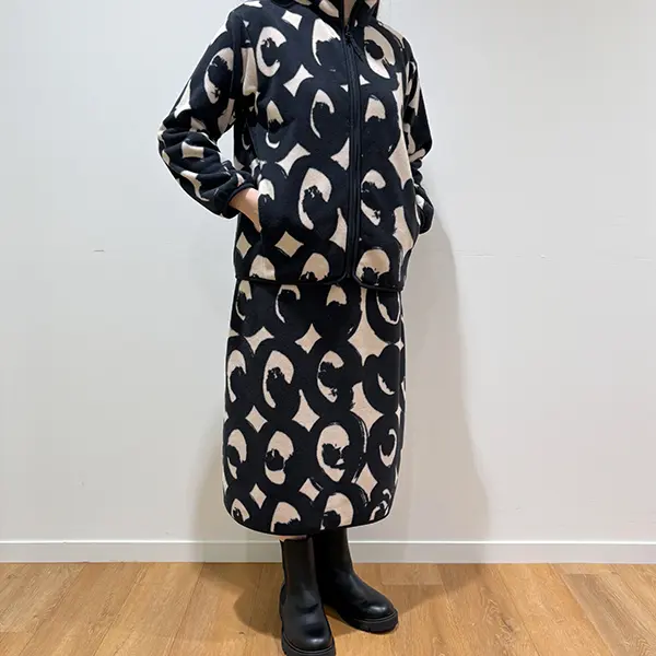 UNIQLO x Marimekko『キッサプッル（モリフクロウ）』柄の「フリースフルジップジャケット（長袖）」と「フリーススカート」を着た女性