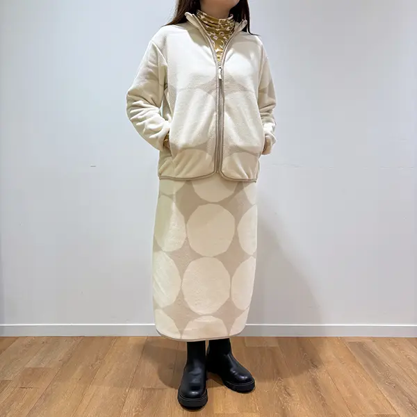 UNIQLO x Marimekko『キヴェット（石）』柄の「フリースフルジップジャケット（長袖）」と「フリーススカート」を着た女性