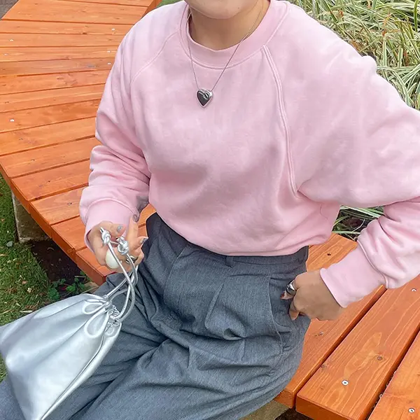 無印良品の「婦人 スウェットシャツ（クルーネック長袖）」ライトピンクカラーを着る女性
