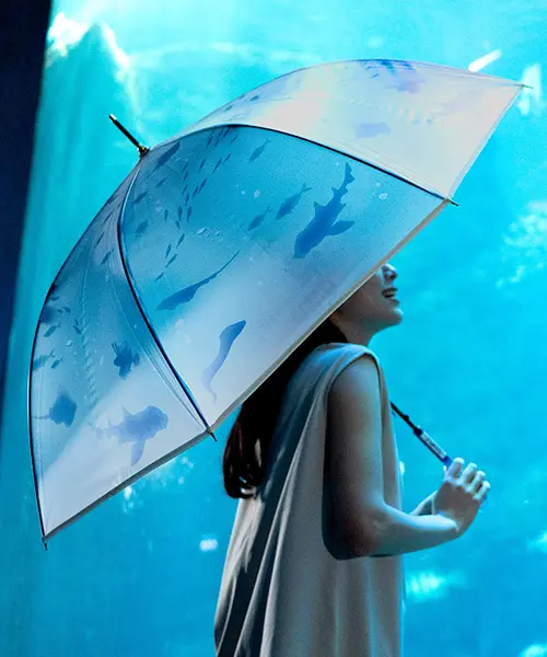 「新江ノ島水族館×Wpc. おはよう、大水槽アンブレラ」をさす女性