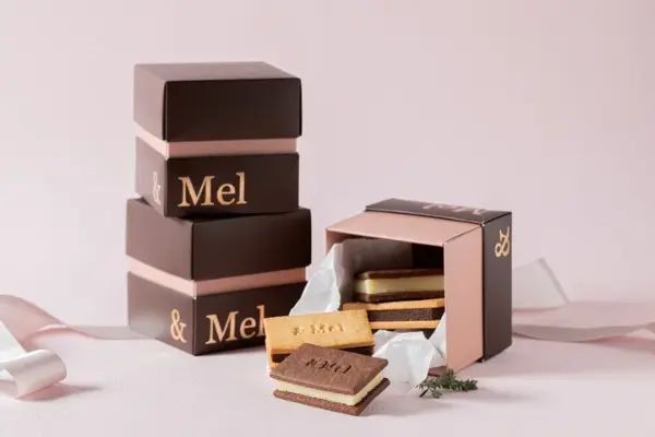 オンライン限定のスイーツブランド「＆Mel」のリニューアルした「食物繊維たっぷり生チョコクッキーサンド」ミルクチョコとホワイトチョコとパッケージ
