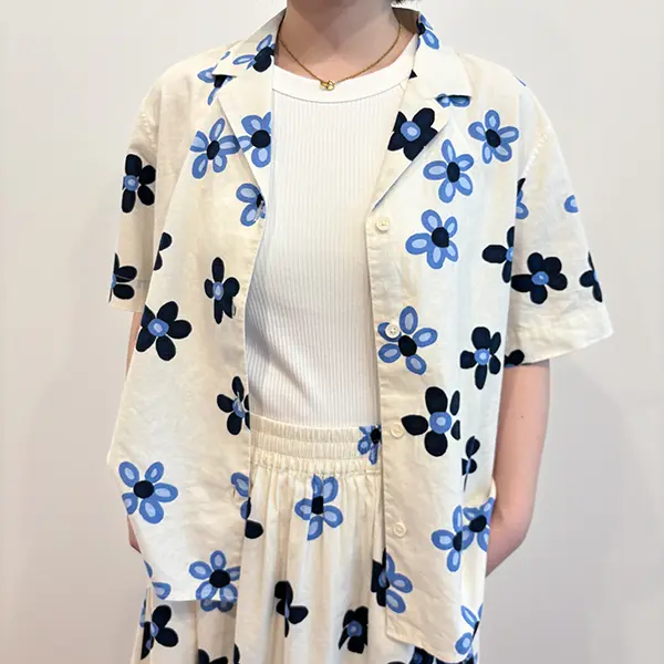 UNIQLO x Marimekkoの「リネンブレンドオープンカラーシャツ（半袖）」『デメテル』柄を着た女性