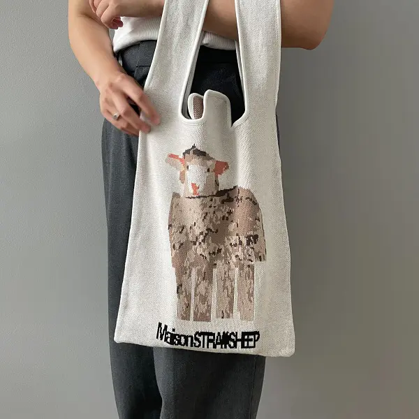 ファッション＆インテリアブランド「MAISON STRAYSHEEP（メゾン ストレイシープ）」のニットバッグ「SHEEP KNIT BAG」を持っている女性