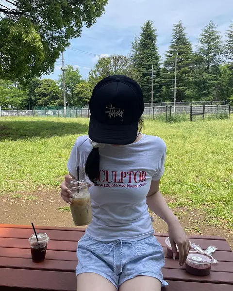 韓国のファッションブランド「SCULPTOR（スカルプター）」とフットボールブランド「UMBRO（アンブロ）」のコラボTシャツアンブロショートスリーブTシャツ」を着ている女性