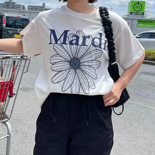 韓国のファッションブランド「Mardi Mercredi（マルディメクルディ）」のTシャツ「SLIM TSHIRT FLOWERMARDI_IVORY NAVY」を着ている女性