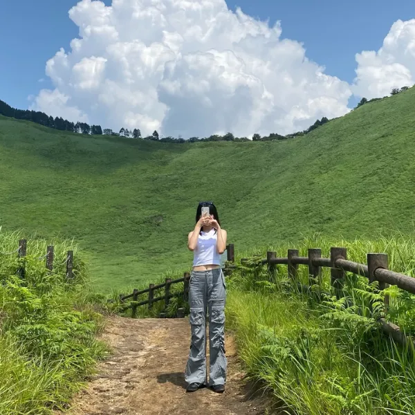 奈良県・宇陀郡にある「曽爾高原（そにこうげん）」で写真を撮っている女性