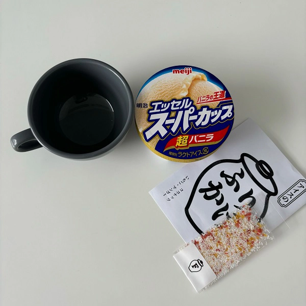 マグカップと、「明治 エッセル スーパーカップ 超バニラ」と、スイーツふりかけ＆珍味ブランド「ふりちん」の「アイスのふりかけ」（フレーバー：『いちご・マンゴー・ココナッツ』）