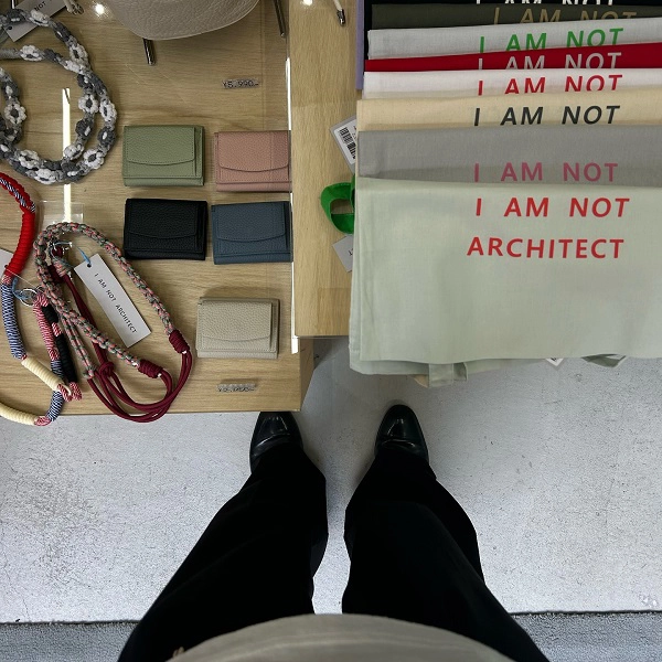 京都・中京区の六角通にある「I AM NOT ARCHITECT」の店内（オリジナルトートやミニ財布、スマホショルダーなどが並ぶ）