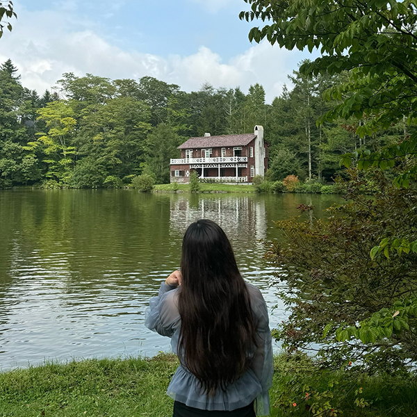 軽井沢のリゾート施設「軽井沢タリアセン」睡鳩荘と写真を撮る女性