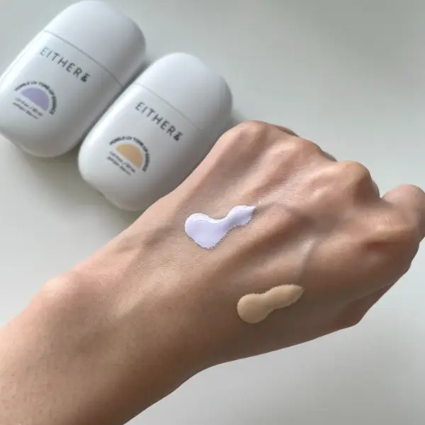 韓国コスメ「EITHER＆（イーザーアンド）」の化粧下地「Pebble UV Tone-up Essence（ペブルUVトーンアップエッセンス）」の『01 スキンベーシュ』と『02 ピュアラベンダー』を手の甲にのせたようす