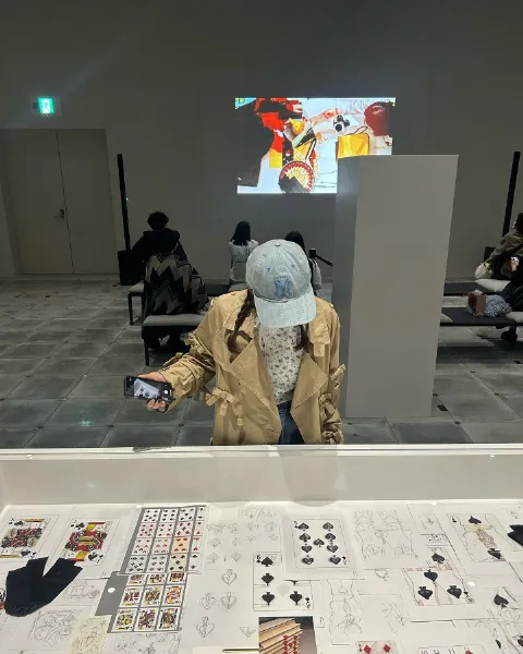 大阪・グラングリーン大阪内にある「VS.（ヴイエス）」にて開催中の吉田ユニさんの展示「PLAYING CARDS」で展示されている作品を鑑賞している女性