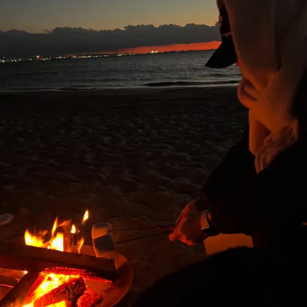 千葉・稲毛海浜公園でできる焚き火「SUNSET BEACH CLUB TAKIBI」をしている女性